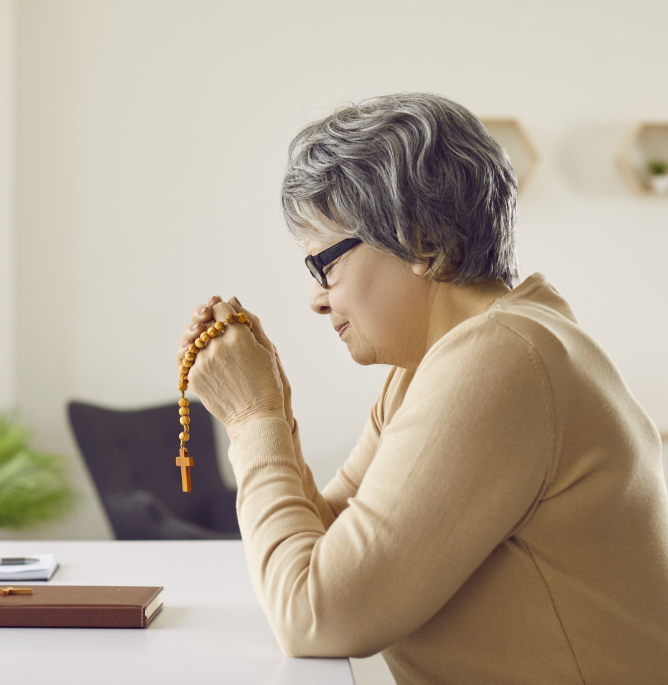 Senior Hispanic woman praying with her rosary