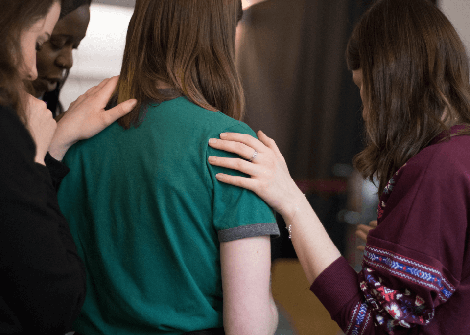 Female church members praying together in a circle